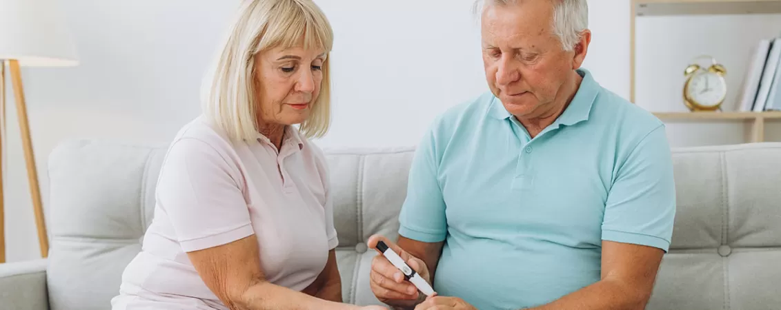 Cuplu de seniori foloseste un glucometru pentru monitorizarea glicemiei