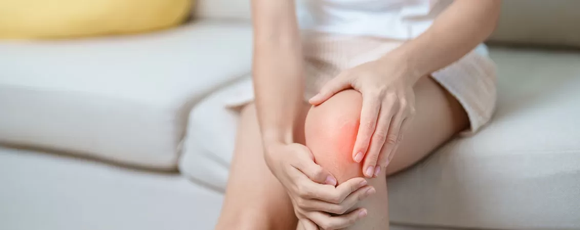 Femeie care resimte durere la genunchi din cauza unei afectiuni articulare