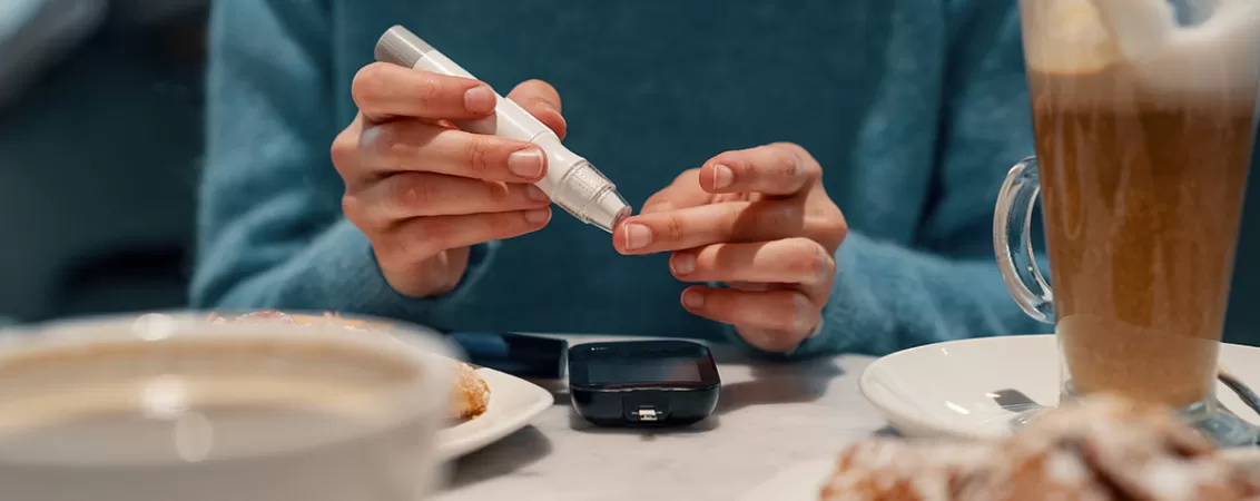 Femeie isi verifica nivelul glicemiei folosind un glucometru portabil