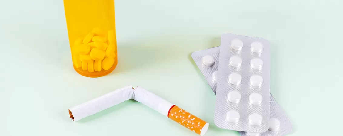 Tigara rupta alaturi de flacon cu medicamente pentru sustinerea renuntarii la fumat