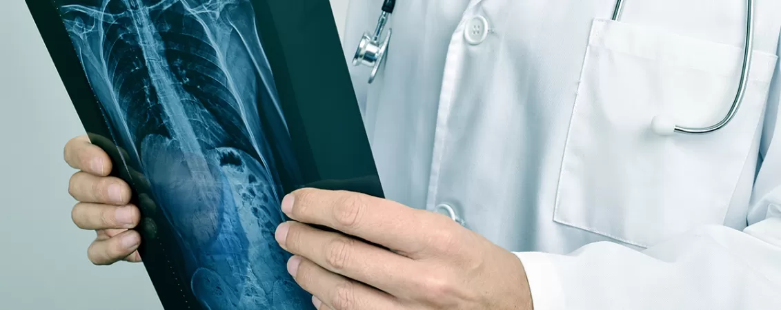 Medic examineaza cu atentie rezultatele unei investigatii in timpul consultatiei medicale