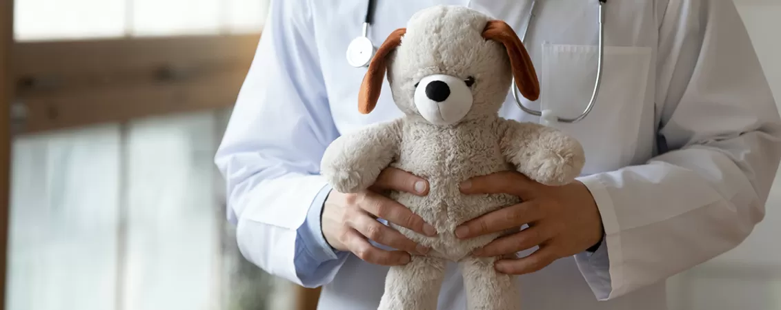 Medic pediatru ține un ursuleț de pluș în mână