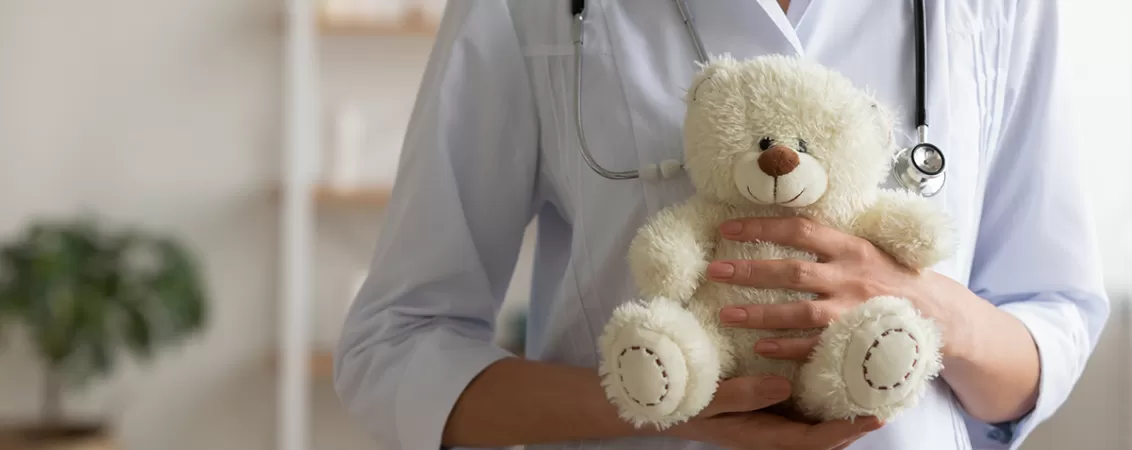 Medic pediatru ține un ursuleț de pluș în mână