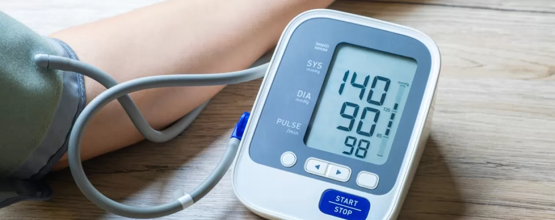 Barbat isi verifica tensiunea arteriala acasa cu ajutorul unui tensiometru digital