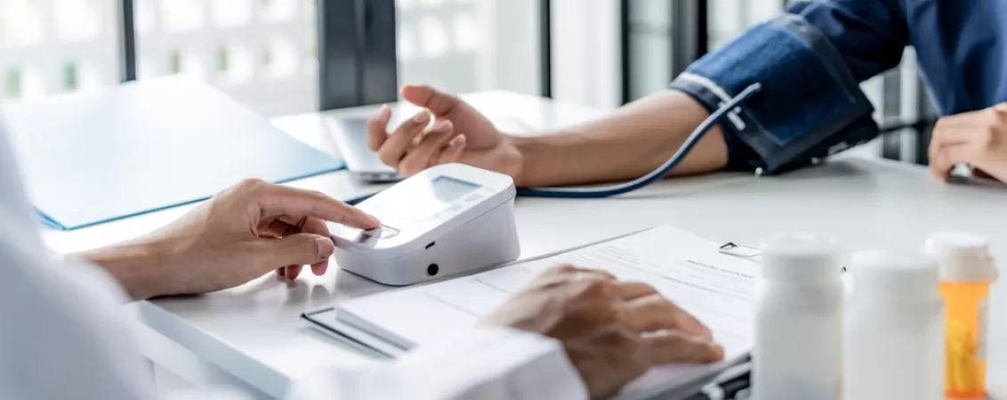 Medic masoara tensiunea arteriala pacientului in timpul unei consultatii medicale