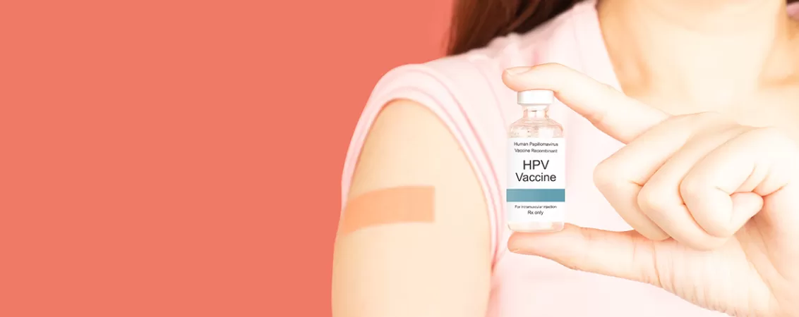 O femeie care tine in mana un flacon cu vaccin impotriva HPV