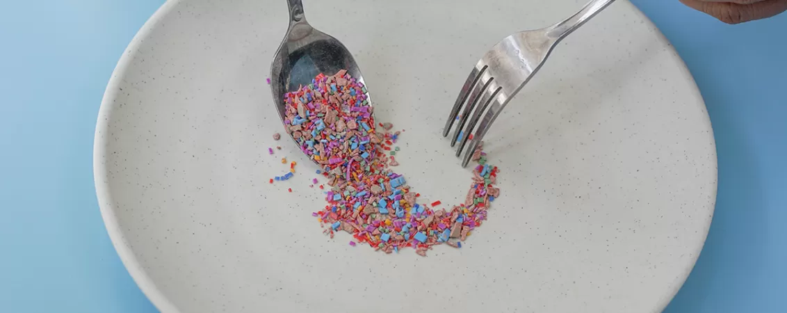 Fragmente de microplastic dispuse pe o farfurie si o lingura