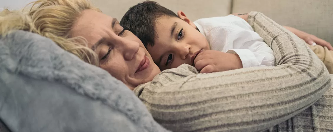 Mama sta intinsa pe canapea alaturi de fiul sau cu autism