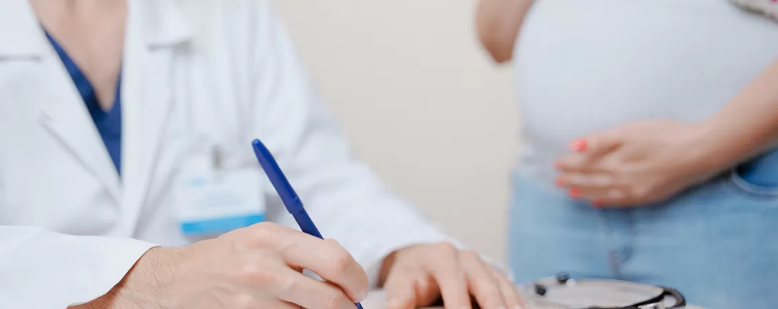 Medic si pacienta discuta despre abdominoplastie intr-o clinica