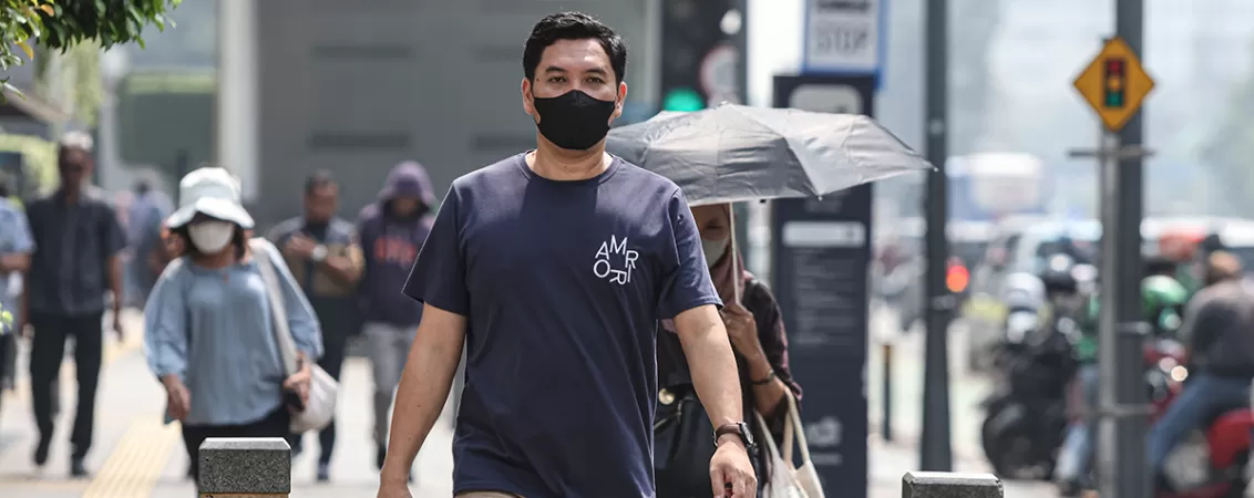 Pietoni purtand masti de protectie impotriva poluarii in Jakarta
