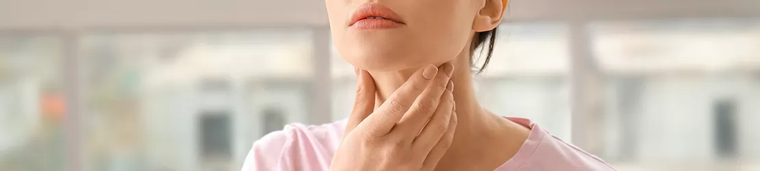 Femeie suferind de hiperparatiroidism isi verifica gatul