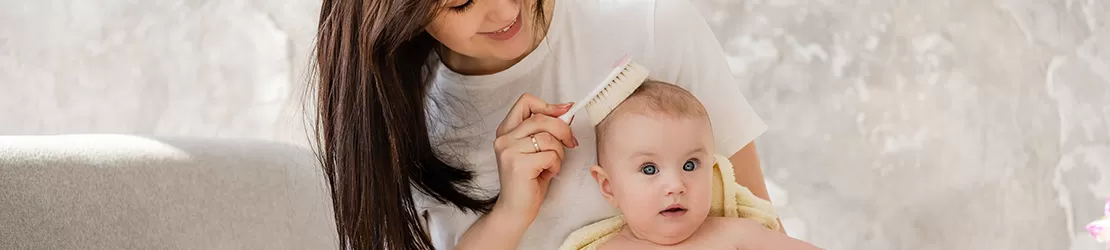 Femeia ingrijeste scalpul bebelusului in caz de Psoriazis seboreic