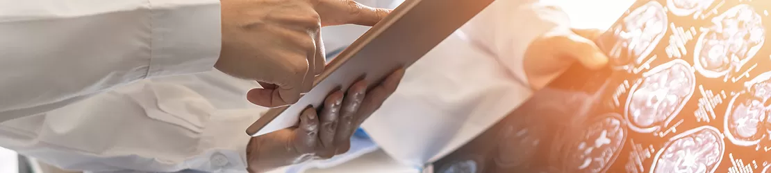 Doi medici analizand si discutand pe baza dosarului medical al unui pacient