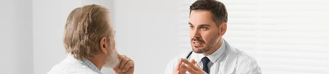 Medic consultand un pacient in varsta in cabinet, discutand despre optiuni de tratament
