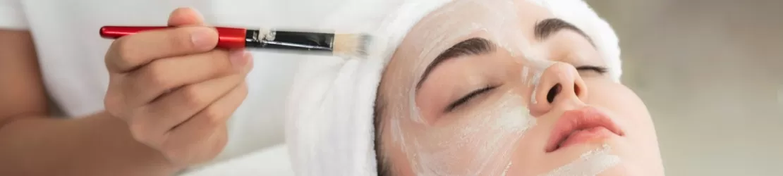 Dermatolog aplicându-i un tratament pentru acnee chistica unei paciente