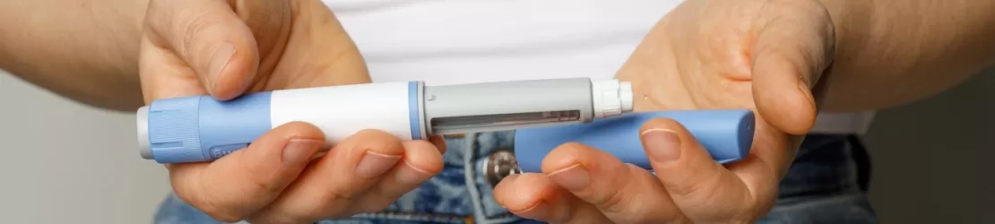 Instrument medical cu insulina in mainile unei femei care sufera de diabet