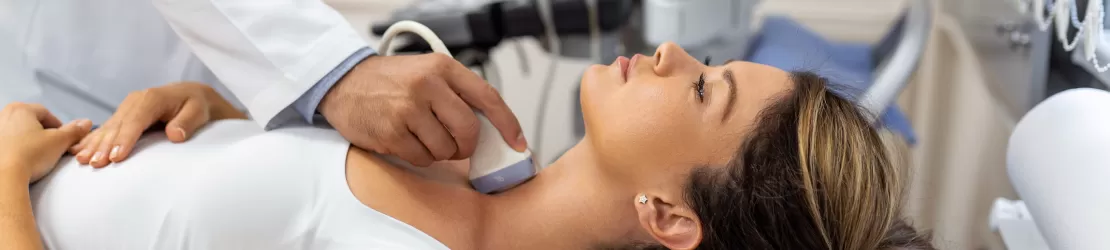 Medic efectuand o ecografie a glandei tiroide