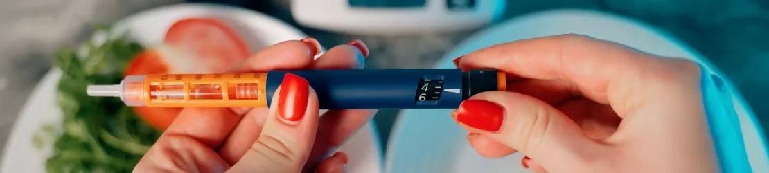 Un glucometru in mainile unei femei care se pregateste sa il foloseasca