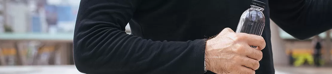 Barbat care tine o sticla de apa in mana