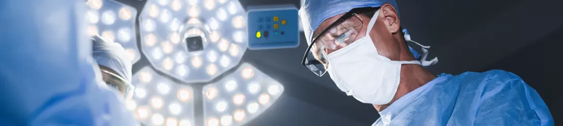 Echipa de medici tratand chirurgical un pacient in sala de operatie