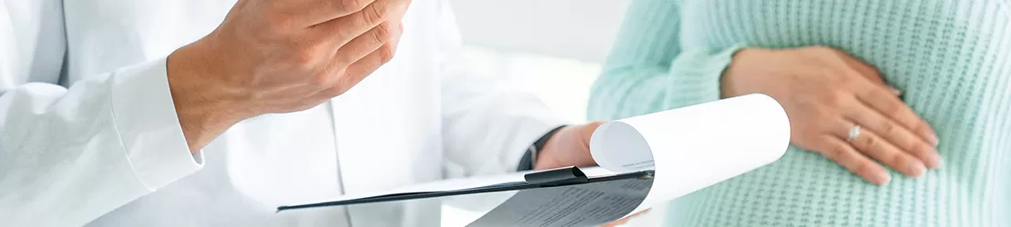 Medic completand fisa medicala a unei femei insarcinate