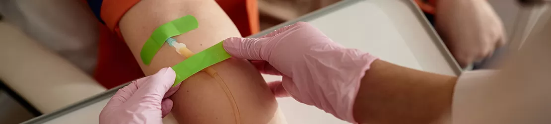 Asistenta care pregateste un pacient pentru perfuzie