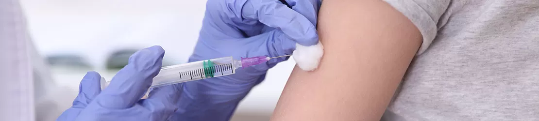 Fetita beneficiind de un vaccin intr-un cabinet medical