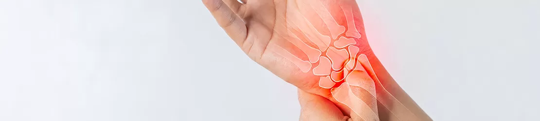 Barbat care isi tine incheietura dureroasa a mainii, semn de durere articulara sau inflamatie