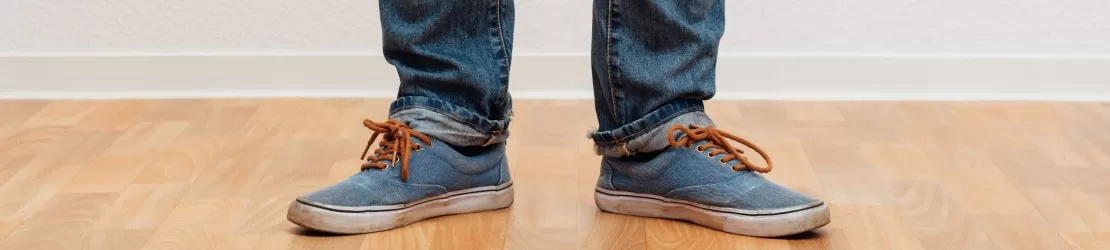 Partea inferioara a unui barbat in picioare cu picioarele in forma de arc, indicand genu varum