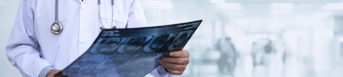 Chirurg ortoped care examineaza radiografia genunchiului unui pacient pentru stabilirea unui diagnostic