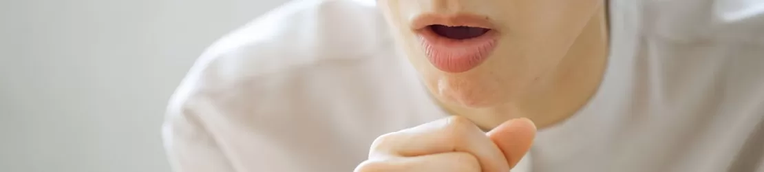 Femeie care tuseste ca simptom asociat cu infectia cu Mycoplasma pneumoniae