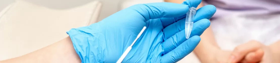 Ginecolog tinand in maini o proba de biomaterial preluata din zona urogenitala a pacientei din cabinet, pentru analize