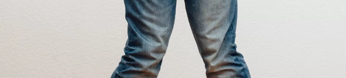 Jumatate inferioara a corpului unui barbat in picioare cu picioarele apropiate pana la genunchi si de la genunchi in jos departate, cu varfurile picioarelor orientate spre interior