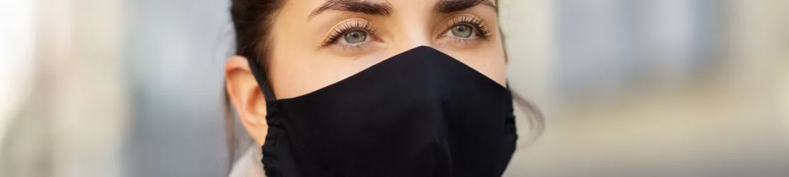 Tanara suferind de gripa de tip B, purtand o masca de protectie neagra