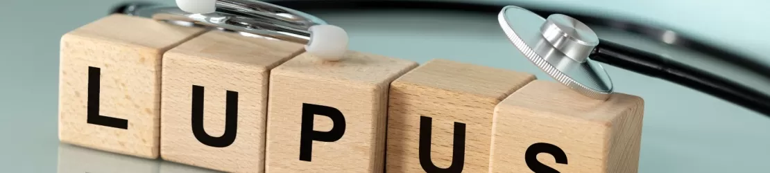 Cuburi din lemn cu litere formand cuvantul lupus, cu un stetoscop deasupra