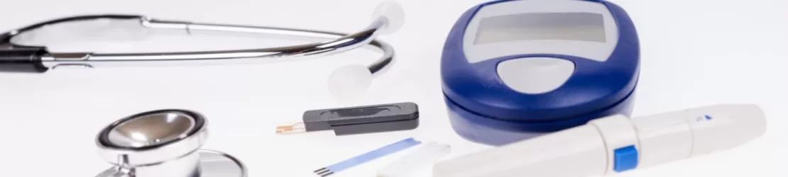 Glucometru pentru masurarea glicemiei alaturi de stetoscop si accesorii medicale, ilustrand monitorizarea diabetului si importanta controlului regulat al nivelului de zahar din sange.