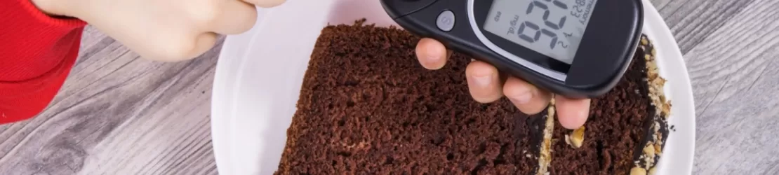 Mana unui copil tinand un glucometru cu rezultat afisat, ilustrand monitorizarea glicemiei si controlul diabetului in randul copiilor.