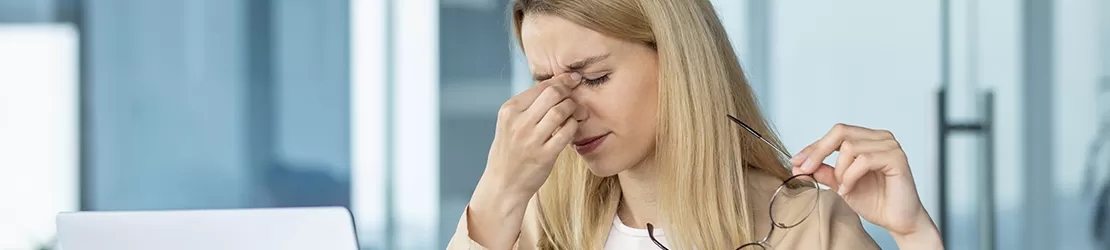 Femeie obosita care lucreaza la birou si resimte stres intens