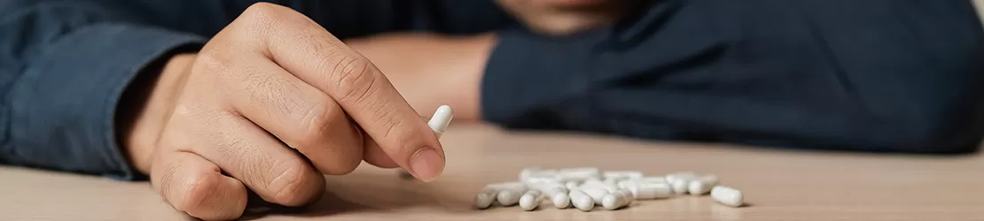 barbat care tine in mana o pastila