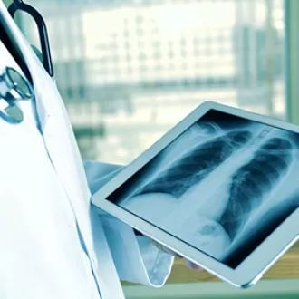 Medic observand imaginea unei radiografii pe tableta