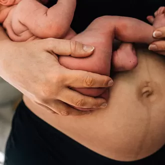 Mama in perioada de lehuzie tinandu-si bebelusul in brate