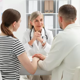 Cuplu la consultatie cu medicul despre fertilizarea in vitro (FIV)