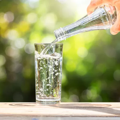 apa turnata din sticla in pahar, pentru a asigura nivelul de hidratare